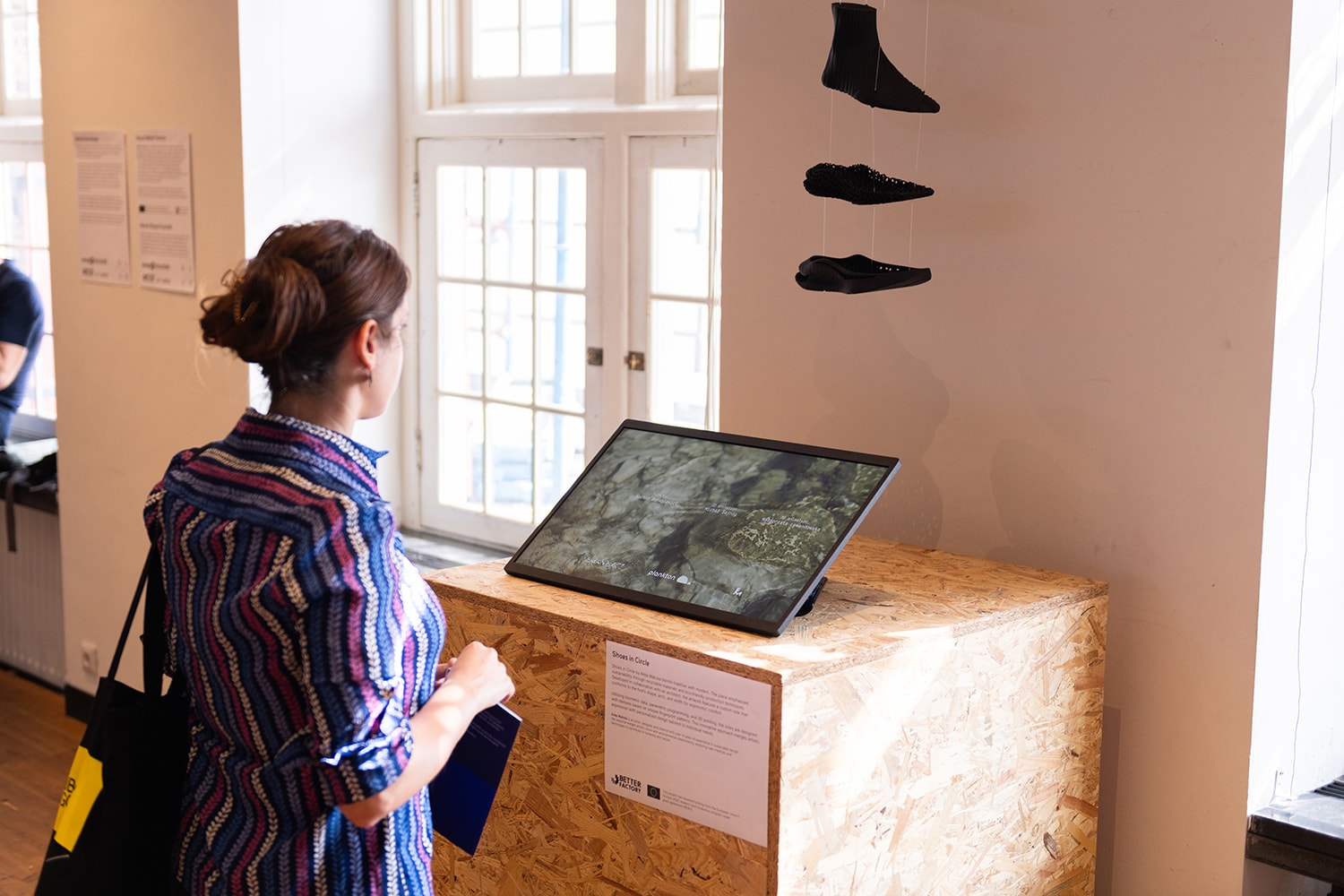Vrouw kijkt naar expo met 3D schoen ontwerp